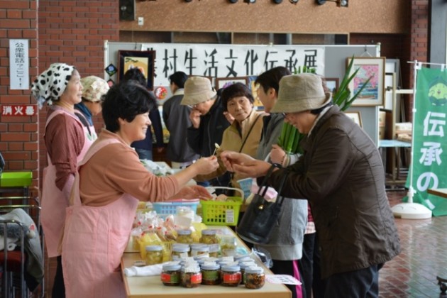 伝承展での一コマ。会員が消費者に試食品を勧めている様子。 